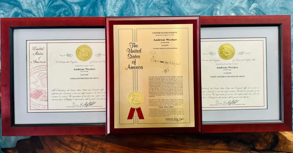 Framed patents awarded to Andreas Wecker for cold-pressed seed oil extraction innovations